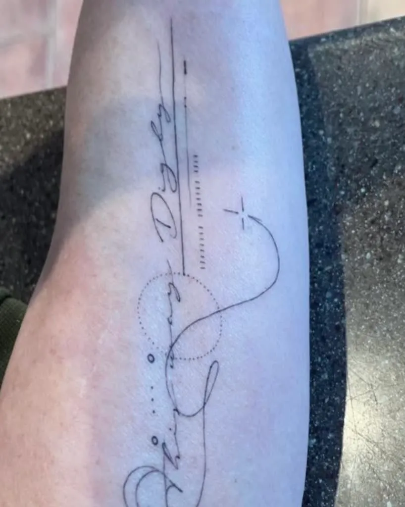 A script tattoo running down a forearm, before laser removal