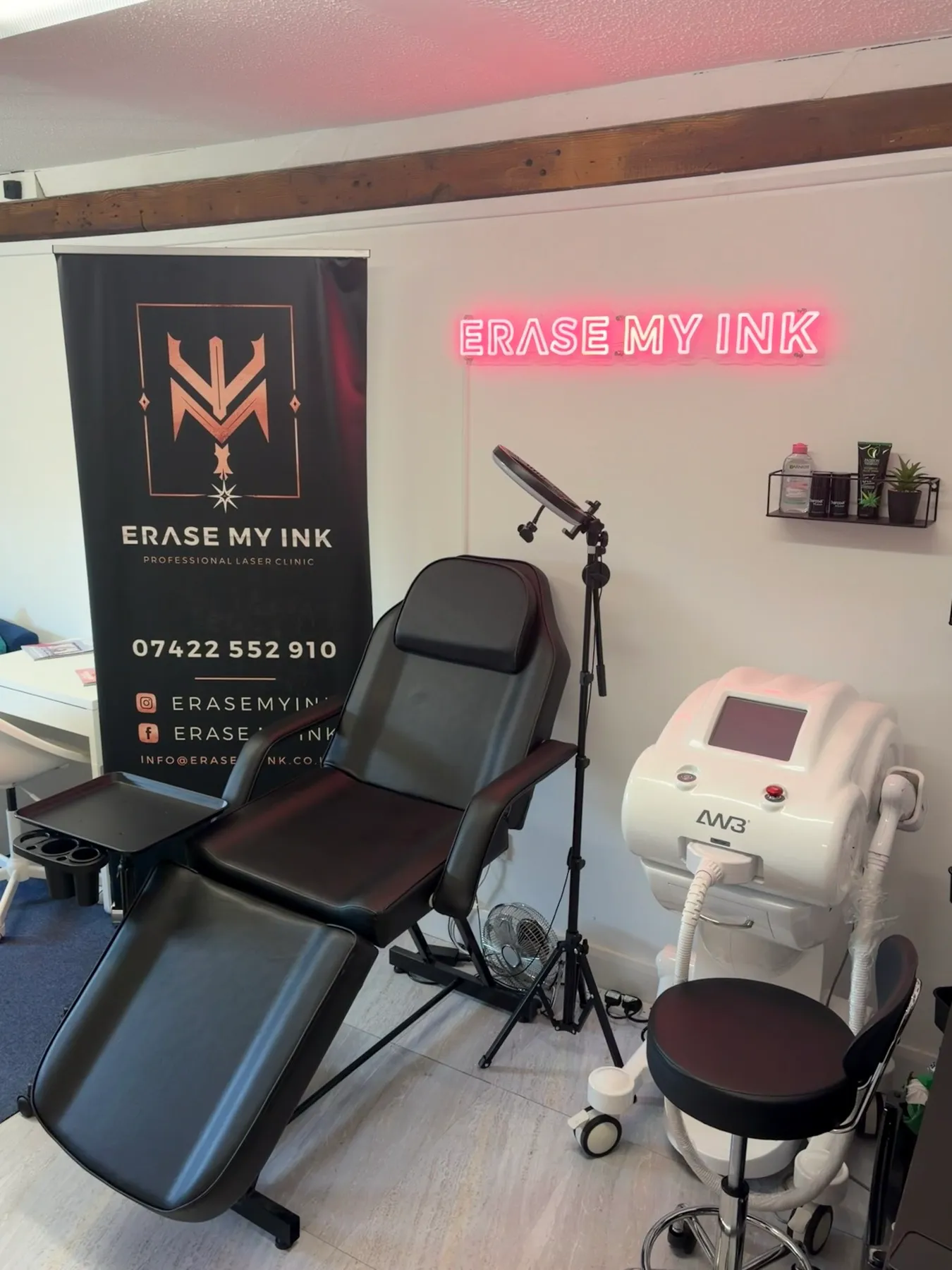 The Erase My Ink treatment room, with the neon sign, treatment chair and laser