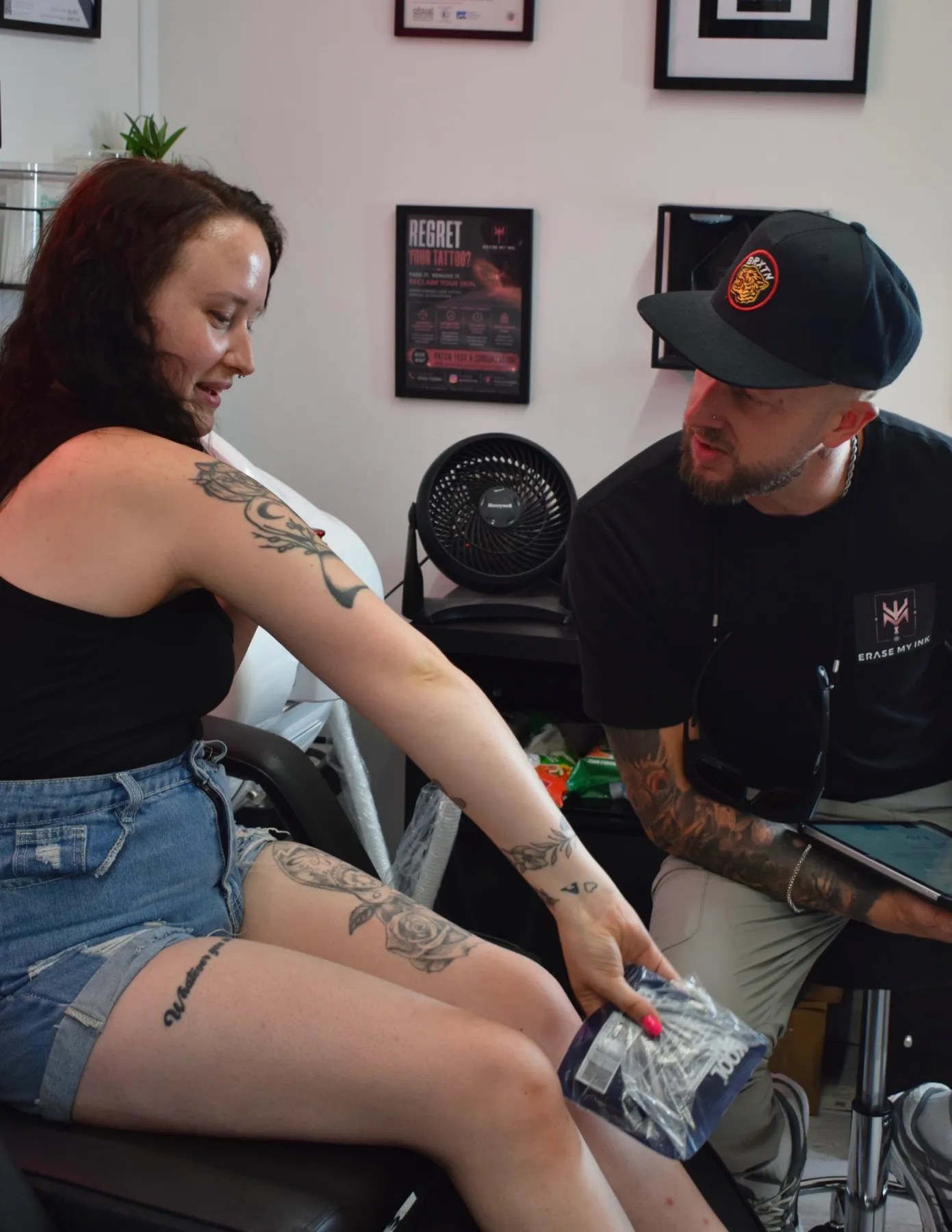 Aaron talking a client through her tattoo at a consultation in the Chelmsford clinic